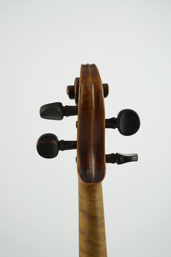 A late 19th century German Nuremberg school violin c.1880, Stradivarius pattern with a finely carved scroll and a large 14.25 inch body, together with a fully mounted German octagonal bow, contained within a contemporary